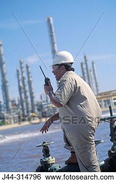 Stock Photo - worker with radio 
in hand at oil 
refinery. fotosearch 
- search stock 
photos, pictures, 
images, and photo 
clipart