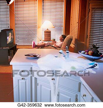 Stock Photo - woman watches 
tv while kitchen 
sink overflows. 
fotosearch - search 
stock photos, 
pictures, images, 
and photo clipart