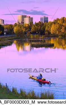 Stock Photo - woman kayaking 
in westchester 
lagoon with anchorage 
skyline in. fotosearch 
- search stock 
photos, pictures, 
images, and photo 
clipart
