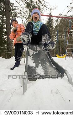 Stock Photo - young girl playing 
in snow and sliding 
down playground 
slide in. fotosearch 
- search stock 
photos, pictures, 
images, and photo 
clipart