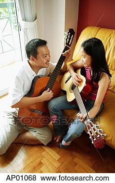 Stock Photo - father and daughter 
holding guitars, 
sitting face to 
face. fotosearch 
- search stock 
photos, pictures, 
images, and photo 
clipart