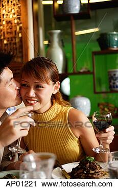 Stock Photography - man kissing woman 
on cheek in restaurant. 
fotosearch - search 
stock photos, 
pictures, images, 
and photo clipart