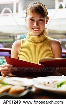 Stock Photograph - woman in cafe, 
holding menu, 
looking at camera, 
smiling. fotosearch 
- search stock 
photos, pictures, 
images, and photo 
clipart