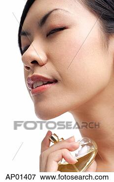 Picture - woman holding 
perfume bottle, 
spraying on neck, 
eyes closed. fotosearch 
- search stock 
photos, pictures, 
images, and photo 
clipart