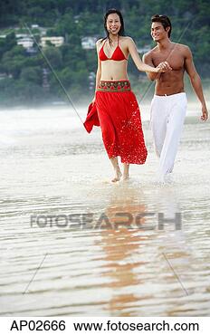 Stock Photo - couple running 
along beach, ankle 
deep in water. 
fotosearch - search 
stock photos, 
pictures, images, 
and photo clipart