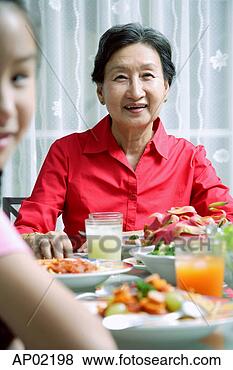 Stock Photo - senior adult at 
dining table, 
 smiling at camera, 
 granddaughter 
in. fotosearch 
- search stock 
photos, pictures, 
images, and photo 
clipart