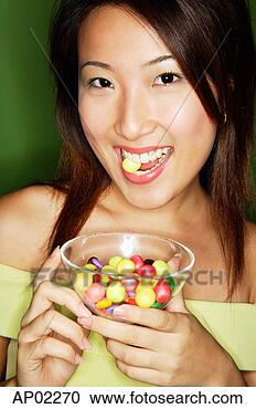 Stock Photography - woman eating candy 
and holding candy 
bowl. fotosearch 
- search stock 
photos, pictures, 
images, and photo 
clipart