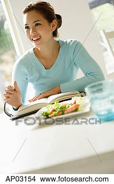 Stock Photo - young woman sitting 
at table,  salad 
on table,  writing 
in notebook. fotosearch 
- search stock 
photos, pictures, 
images, and photo 
clipart