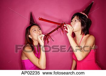 Stock Image - young women wearing 
party hats, blowing 
noisemakers. fotosearch 
- search stock 
photos, pictures, 
images, and photo 
clipart