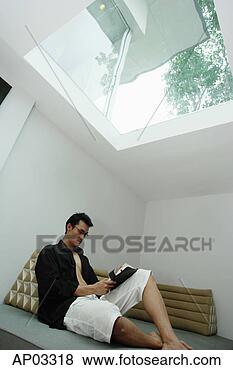 Stock Photo - man sitting at 
home, reading 
a book. fotosearch 
- search stock 
photos, pictures, 
images, and photo 
clipart
