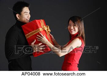 Stock Photo - young man giving 
gift to woman, 
woman turning 
to smile at camera. 
fotosearch - search 
stock photos, 
pictures, images, 
and photo clipart