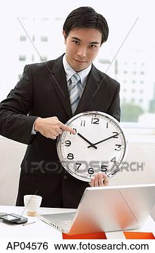 Stock Photo - businessman holding 
and pointing at 
clock. fotosearch 
- search stock 
photos, pictures, 
images, and photo 
clipart