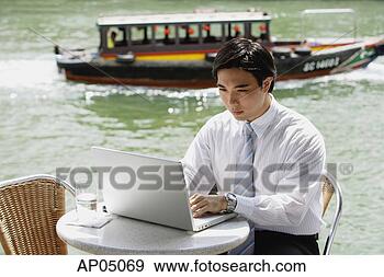 Stock Photograph - businessman sitting 
at outdoor cafe, 
 using laptop, 
 river in the. 
fotosearch - search 
stock photos, 
pictures, images, 
and photo clipart