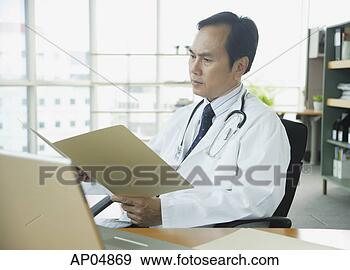 Stock Photograph - doctor in office, 
looking at folder. 
fotosearch - search 
stock photos, 
pictures, images, 
and photo clipart