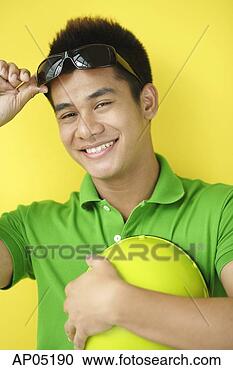 Stock Photography - man carrying helmet, 
adjusting sunglasses, 
looking at camera. 
fotosearch - search 
stock photos, 
pictures, images, 
and photo clipart