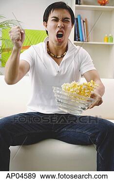 Stock Photograph - man holding bowl 
of popcorn, making 
a fist. fotosearch 
- search stock 
photos, pictures, 
images, and photo 
clipart