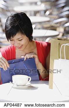 Picture - woman at cafe, 
looking in shopping 
bag. fotosearch 
- search stock 
photos, pictures, 
images, and photo 
clipart