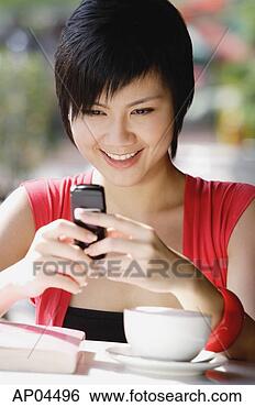 Stock Photo - woman at cafe 
using mobile phone, 
text messaging. 
fotosearch - search 
stock photos, 
pictures, images, 
and photo clipart