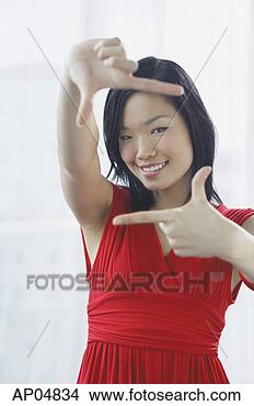 Stock Photo - woman making a 
finger frame, 
smiling at camera. 
fotosearch - search 
stock photos, 
pictures, images, 
and photo clipart