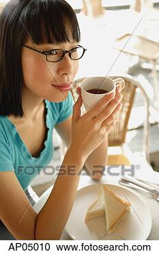 Stock Photography - young woman having 
coffee, looking 
away. fotosearch 
- search stock 
photos, pictures, 
images, and photo 
clipart