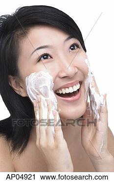 Stock Photography - young woman putting 
facial cleanser 
on her face. fotosearch 
- search stock 
photos, pictures, 
images, and photo 
clipart