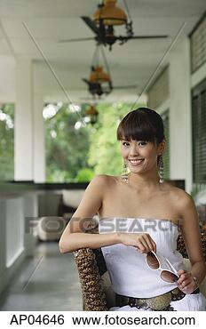 Stock Photo - young woman in 
white tube top 
dress,  holding 
sunglasses,  looking 
at. fotosearch 
- search stock 
photos, pictures, 
images, and photo 
clipart