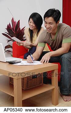 Stock Photography - couple at home 
in living room, 
doing finances. 
fotosearch - search 
stock photos, 
pictures, images, 
and photo clipart