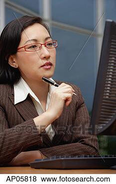 Stock Photo - female executive 
holding pen, looking 
at computer monitor. 
fotosearch - search 
stock photos, 
pictures, images, 
and photo clipart
