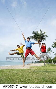 Picture - three men  on 
beach, jumping 
in air, looking 
at camera. fotosearch 
- search stock 
photos, pictures, 
images, and photo 
clipart