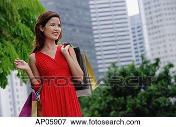 Picture - woman in red dress 
carrying shopping 
bags, city location. 
fotosearch - search 
stock photos, 
pictures, images, 
and photo clipart