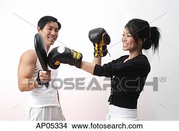 Stock Photo - young woman with 
boxing gloves, 
practicing with 
trainer. fotosearch 
- search stock 
photos, pictures, 
images, and photo 
clipart