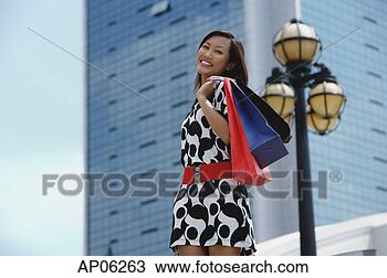 Stock Photo - woman carrying 
shopping bags, 
smiling at camera. 
fotosearch - search 
stock photos, 
pictures, images, 
and photo clipart