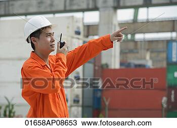 Stock Photo - construction worker 
giving directions 
on walkie talkie. 
fotosearch - search 
stock photos, 
pictures, images, 
and photo clipart