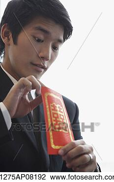 Stock Photo - a groom looks 
inside a red envelope. 
fotosearch - search 
stock photos, 
pictures, images, 
and photo clipart