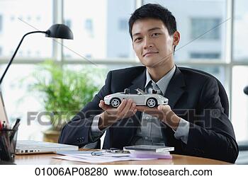 Stock Photography - a man looks at 
the camera as 
he holds a toy 
car. fotosearch 
- search stock 
photos, pictures, 
images, and photo 
clipart