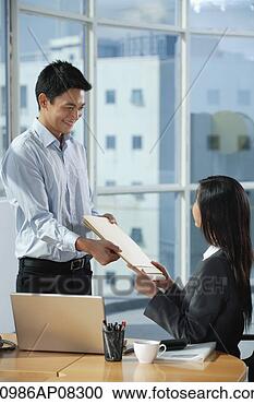 Stock Photography - two colleagues 
smile at each 
other as they 
exchange documents. 
fotosearch - search 
stock photos, 
pictures, images, 
and photo clipart