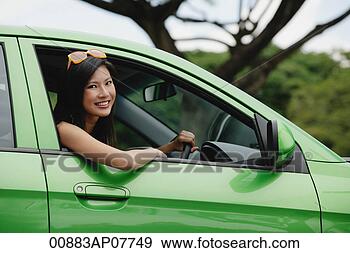 Stock Photograph - a young woman 
drives a green 
car. fotosearch 
- search stock 
photos, pictures, 
images, and photo 
clipart