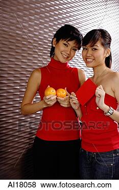 Stock Photo - young women dressed 
in red,  holding 
two oranges and 
red packet. fotosearch 
- search stock 
photos, pictures, 
images, and photo 
clipart