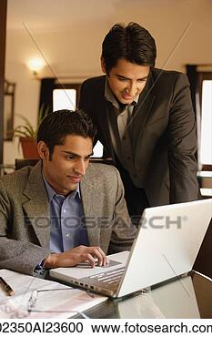 Stock Photography - two men working 
at laptop. fotosearch 
- search stock 
photos, pictures, 
images, and photo 
clipart