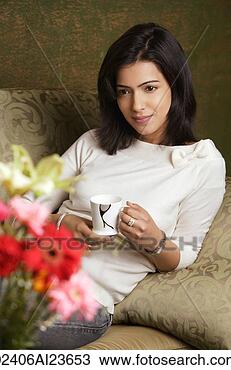 Stock Photo - woman reclines 
on arm holding 
cup of tea. fotosearch 
- search stock 
photos, pictures, 
images, and photo 
clipart
