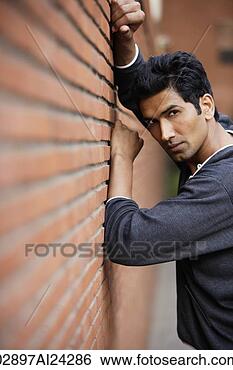 Stock Photo - man posing against 
brick wall. fotosearch 
- search stock 
photos, pictures, 
images, and photo 
clipart