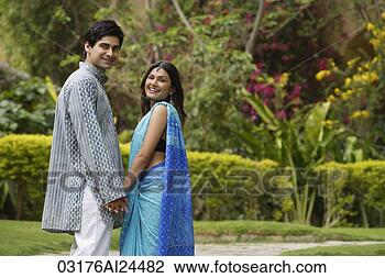 Stock Photo - young couple in 
garden, turning 
back smiling. 
fotosearch - search 
stock photos, 
pictures, images, 
and photo clipart