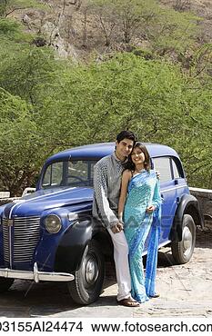 Stock Photo - young couple standing 
in front of blue 
antique car. fotosearch 
- search stock 
photos, pictures, 
images, and photo 
clipart