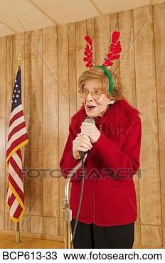 Stock Photo - elderly woman 
at microphone 
at christmastime. 
fotosearch - search 
stock photos, 
pictures, images, 
and photo clipart