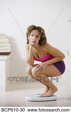 Stock Photography - woman crouching 
on bathroom scale. 
fotosearch - search 
stock photos, 
pictures, images, 
and photo clipart