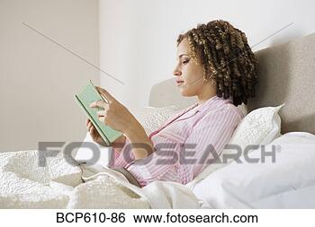 Stock Photo - woman reading 
book in bed. fotosearch 
- search stock 
photos, pictures, 
images, and photo 
clipart