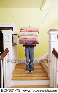 Stock Photo - child carrying 
tall stack of 
towels on stairs. 
fotosearch - search 
stock photos, 
pictures, images, 
and photo clipart