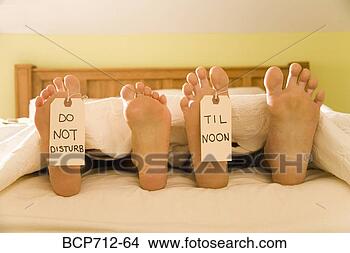 Stock Photo - couple’s bare 
feet with do not 
disturb til noon 
signs. fotosearch 
- search stock 
photos, pictures, 
images, and photo 
clipart