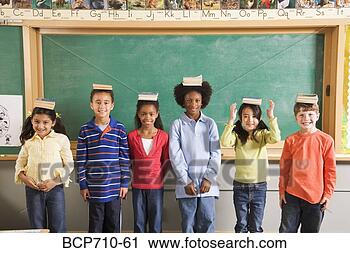 Stock Photography - row of students 
with books on 
their heads in 
classroom. fotosearch 
- search stock 
photos, pictures, 
images, and photo 
clipart