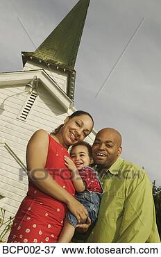 Picture - a family standing 
close together 
in front of white 
church. fotosearch 
- search stock 
photos, pictures, 
images, and photo 
clipart